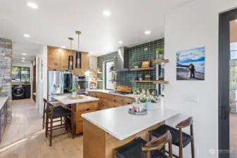 In the kitchen, forest green tiles on the range and sink wall echo the grid patterns found in the windows, and floating shelves maintain a horizontal theme.