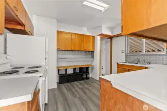 Mid Century Kitchen has wood cabinets, Vinyl plank floor, tin backsplash, formica counter tops.