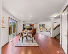 Overall view of the main floor.  Side yard out the slider door heads to the fully fenced back yard.  Interior garage entrance/exit seen to your right and stairs leading to the upper level.