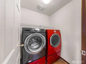 Laundry room has it's own door, with front loading washer/dryer with lower storage bins and an upper storage rack too.
