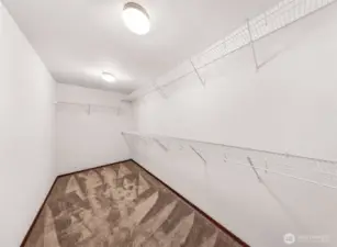 This primary suite's closet is HUGE!  Closet rack system in place for all your stuff.  The storage space here is deep.