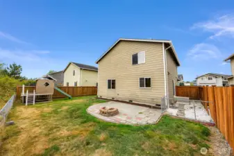 Playhouse to your left, patio at center and a fenced area off of the side porch.