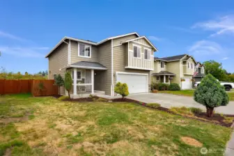 Side yard of home seen here with a fully fenced yard and covered front porch.