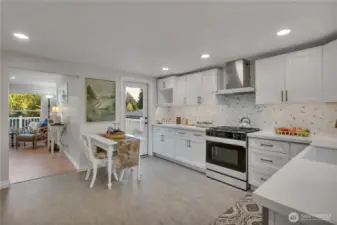 This view gives you a look at the kitchen door to the wrap around porch.  Quartz countertops, under cabinet lights, countertop to ceiling tile--nice.