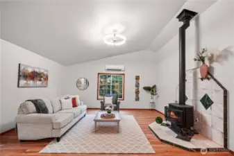 Inviting living room highlights a propane fireplace, fresh paint, mini split, new lighting and new LVP flooring. Perfect for relaxing or entertaining in comfort.