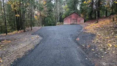 New black crushed rock driveway leading to barn.