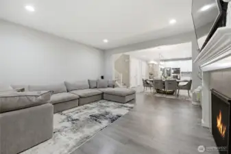 Spacious living room with gas fireplace opens to dining and kitchen