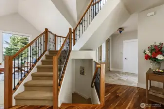 View of the front entrance/marble foyer with double coat closets and door to the 2 car garage, plus another set of washer/dryer on the landing.