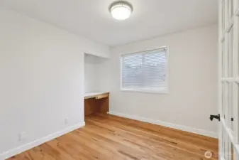 Freshly painted Den with built-in desk and door for added privacy.