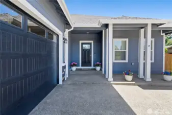 Welcoming front entry with a covered porch, modern finishes, and spacious attached garage.
