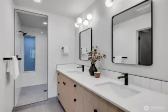 Modern ensuite featuring dual sinks, matte-black fixtures and large walk in shower.
