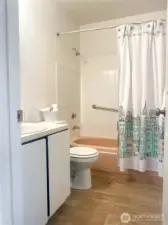 Hallway bathroom with new vent and grouting.