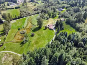 28 acres teeming with wildlife, lush meadows, a natural pond, and a flowing stream.