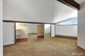 The MIL bedroom #5 featuring a vaulted ceiling with exposed wood beam and ample double-door closet space.