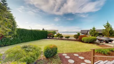 Professionally well-maintained front yard with lush greenery and a direct view of Lake Tapps—perfect for enjoying the island lifestyle.