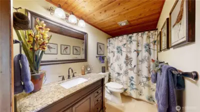 Charming hall bath with granite vanity and tile floors