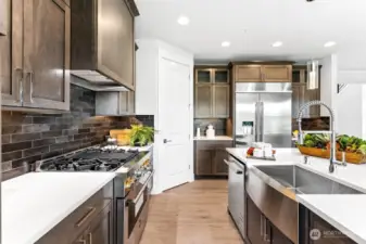 Gorgeous Kitchen with JennAir appliances, gas range/oven, beverage fridge, pantry, quartz, deep sink, and wall mounted oven/micro.