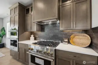 Gas range and full height tile backsplash.
