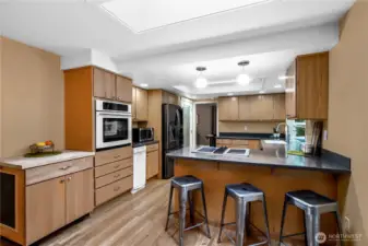 Spacious kitchen featuring abundant storage, an updated smart refrigerator and dishwasher, plus convenient counter seating.