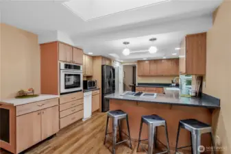 Spacious kitchen featuring abundant storage, an updated smart refrigerator and dishwasher, plus convenient counter seating.