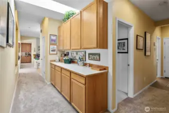 Hallway looking back towards the front entry and primary bedroom, LOOK at all the custom built ins TONS of storage!