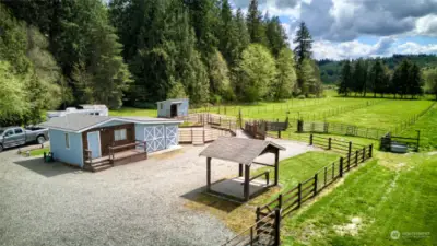 Parking and loading areas with covered hitching post. One bedroom cabin with 3/4 bath and hay storage shed (left/center)