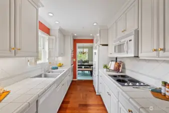 kitchen boasts beautiful white cabinetry with pull-outs, engineered hardwood floor
