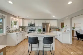 Open kitchen with island, quartz counters, shaker style cabinets