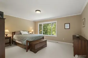 The primary suite with crown molding and tranquil backyard views features 2 walk-in closets and an updated 5 piece bathroom with soaking tub, tiled shower, dual vanities and tile floor.