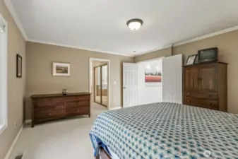 The primary suite with crown molding and tranquil backyard views features 2 walk-in closets and an updated 5 piece bathroom with soaking tub, tiled shower, dual vanities and tile floor.
