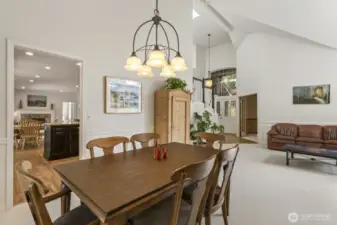 The open and spacious formal living and dining rooms boast tall vaulted ceilings and wainscoted walls.