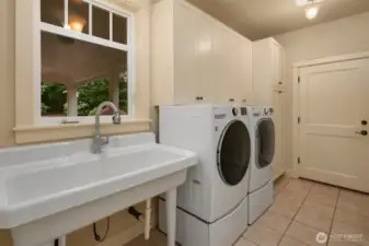 Mud room with porcelain farm sink, custom cabinetry, washer/dryer and garage access
