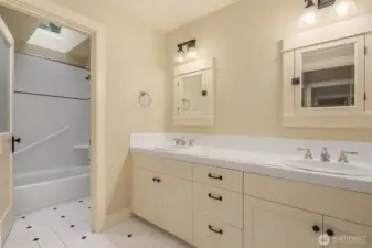 Upper level full bathroom with double vanity and skylight