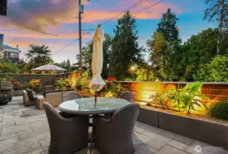 Patio facing north with landscaping lighting and gas plumbed BBQ. There was previously a 2-person hot tub in the corner beyond the open umbrella.