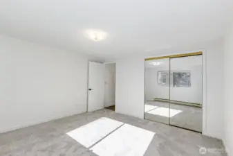 Another view of bedroom reflecting full length mirrored closet doors.