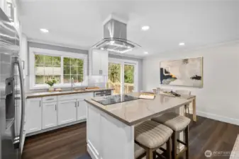 Remodeled in 2025, the kitchen features all new GE appliances installed in 2025. Crisp modern cabinetry stretches along the walls, offering abundant storage while keeping the lines clean and refined. Soft under cabinet lighting adds a warm glow across the counters in the evening, highlighting the thoughtful design and creating an inviting atmosphere for both everyday living and entertaining. In the evenings, that gentle illumination provides just the right amount of light for meal prep or late night conversations, allowing the space to feel comfortable and relaxed without relying solely on overhead lighting. Quartz counters extend along both sides, providing ample room for preparing meals, arranging ingredients, or keeping small appliances within reach. Multiple outlets along the backsplash support everyday cooking and baking needs while maintaining the kitchen’s cohesive look.