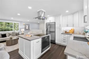 White shaker cabinetry extends to the ceiling, offering extensive storage and a clean, timeless profile. Brushed metal pulls add a simple, modern accent that complements the cabinetry without overpowering it.  Quartz counters in soft gray tones provide a smooth, refined surface that pairs beautifully with the warm hardwood tone of the luxury vinyl flooring. The stainless steel GE French door refrigerator includes a built in water dispenser and ice maker for everyday ease. The matching GE oven, seamlessly tucked into the island, continues the cohesive stainless finish and modern functionality introduced during the remodel.