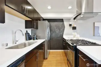 The kitchen features stainless appliances, gas cooking, Quartz counters, a stylish vent hood and blackboard wall.