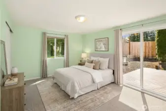 Primary bedroom out to the trex deck and raised garden planters -- Virtually staged