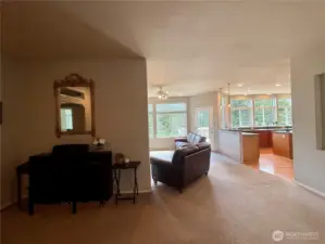 Looking from the entry towards the family room and kitchen with music and bonus gathering space to the left.