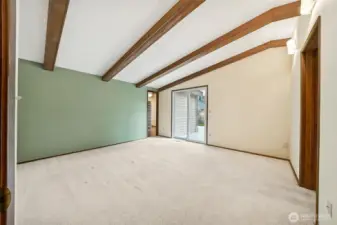 Primary bedroom continues the beautiful exposed beams and vaulted ceilings.