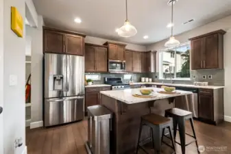 Stylish kitchen featuring rich cabinetry, stainless steel appliances, and a large island.