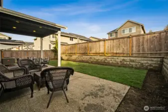 Extended patio space overlooking a generous lawn — ideal for gatherings and BBQs.