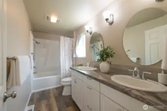Primary bath with dual sink vanity and a tub/shower combo.
