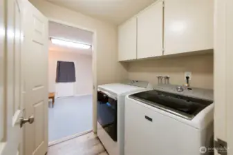 Laundry room with sink and built-in cabinetry for extra storage space.