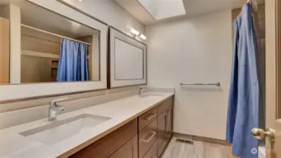 Full bathroom on upper level offers double sinks and a huge skylight.