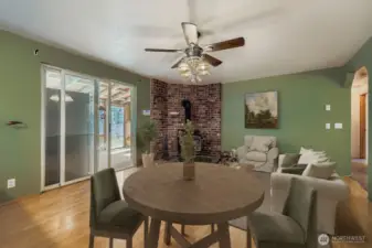 COZY DINING AREA WITH EASY ACCESS TO KITCHEN AND RELAXING WOOD STOVE.