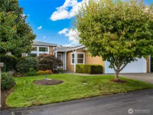 Lush trees and green grass adorns this beautiful home.