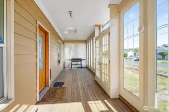Gorgeous enclosed front porch with pet door. Perfect for plants, pets, or perusing a good book!