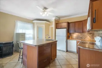 The kitchen has deep countertops and an alluring backsplash all the way up to the cabinetry.